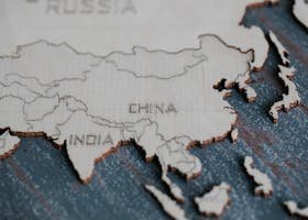 Detailed view of Asia carved on a wooden map, highlighting China and India.