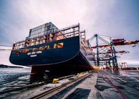 A large cargo ship docked at Gothenburg port with industrial cranes, Sweden.